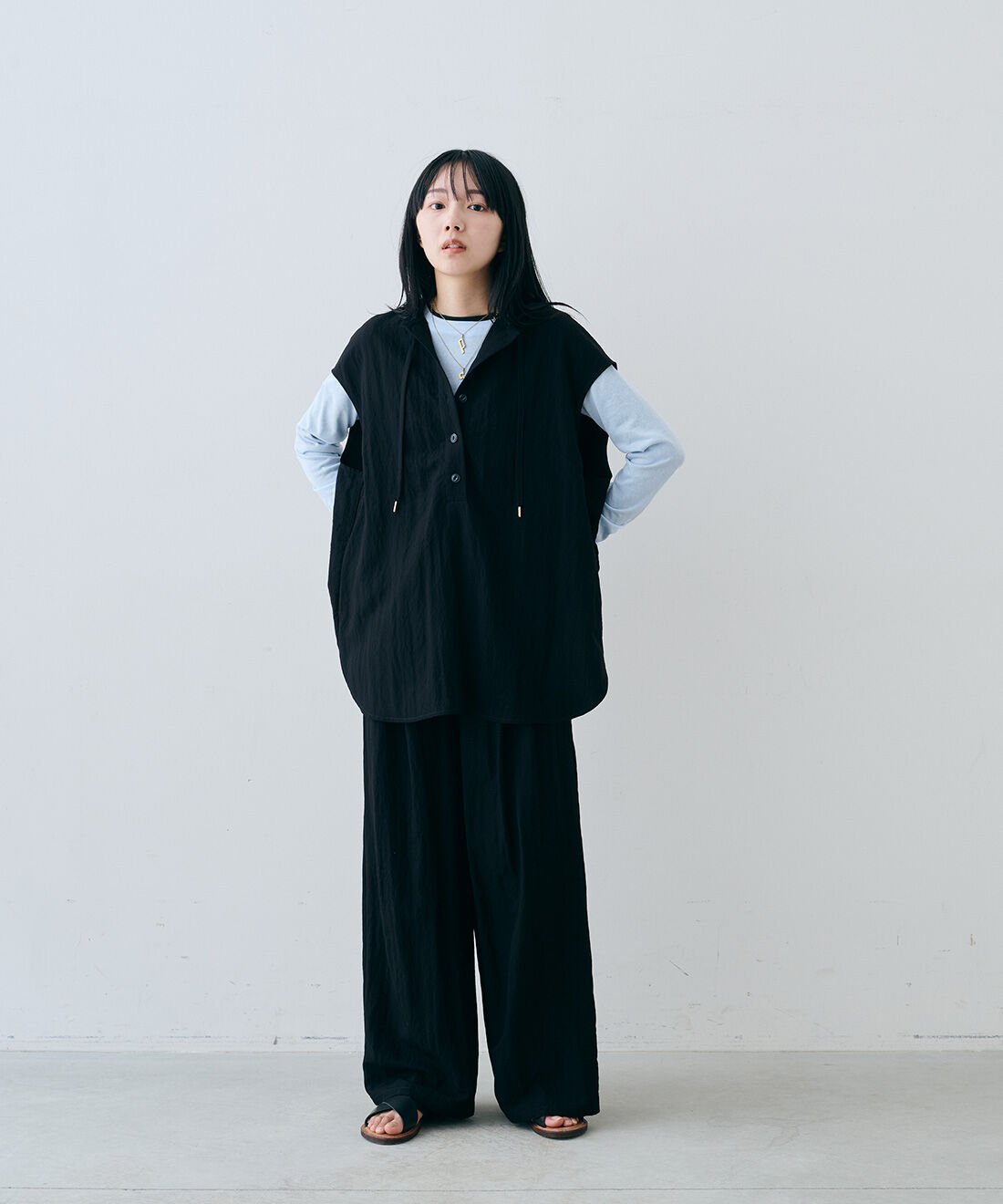 MEDE19F|レーヨン混のシャリ感のあるノースリーブ フーディー〈ブラック〉とレーヨン混のシャリ感のあるワイドスラックス〈ブラック〉とヴィンテージパーツイニシャルネックレスとEDER SHOES 1542 NERO / 13のコーディネート